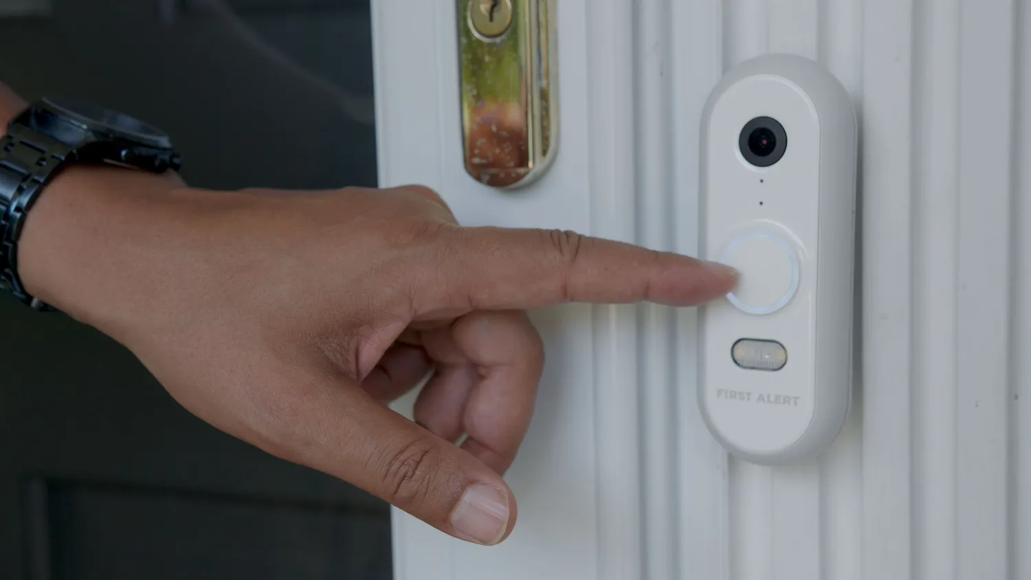 First Alert wired video doorbell being pressed